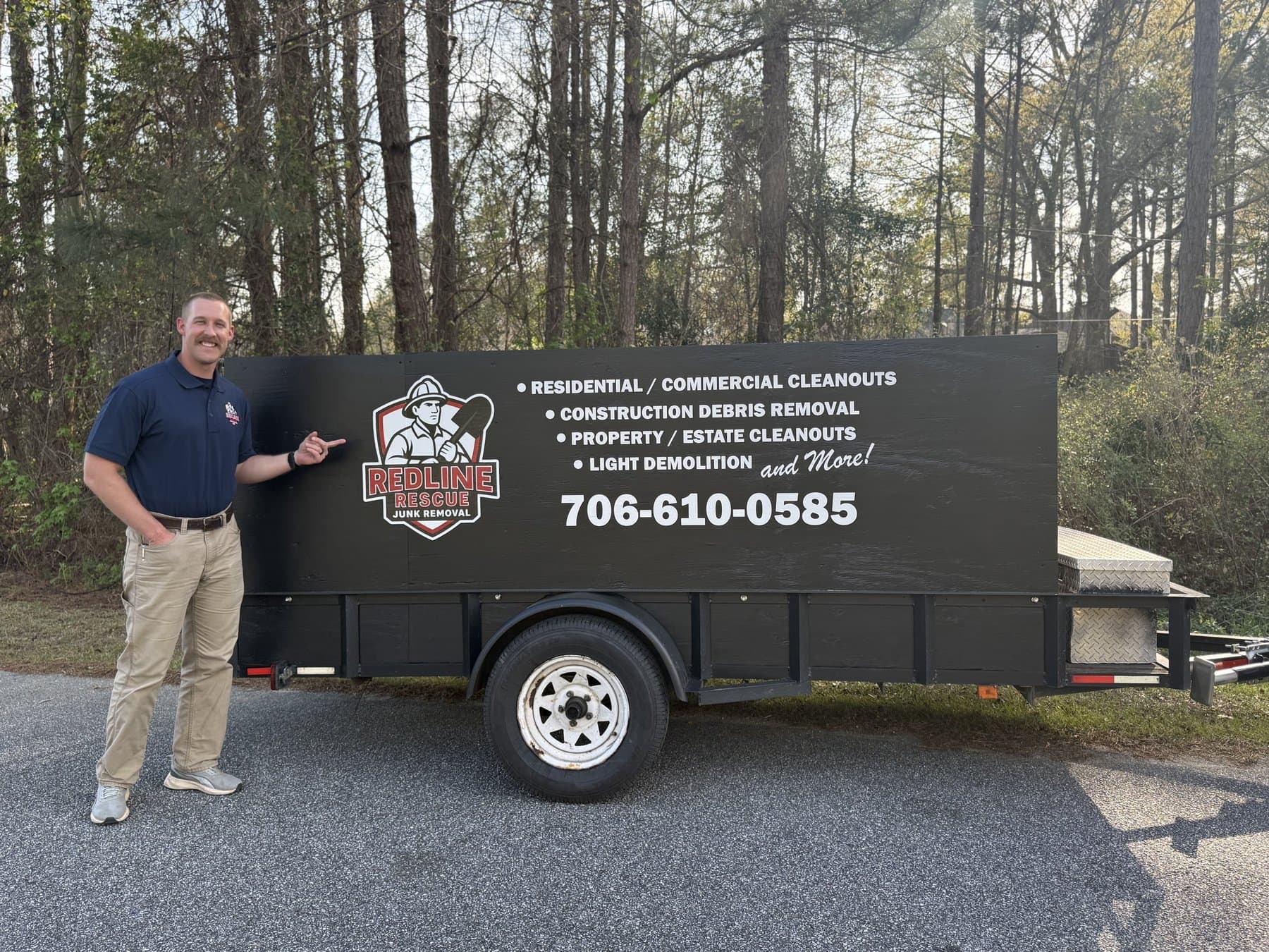 David, owner of Redline Rescue Junk Removal, standing beside the Redline Rescue trailer
